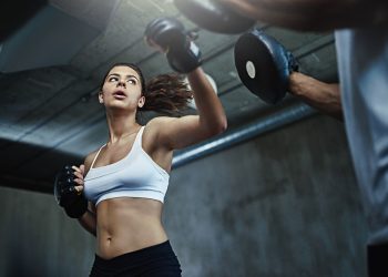 Shot of a young woman sparring with a boxing partner at the gym