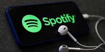 Spotify logo displayed on a phone screen and headphones are seen in this illustration photo taken in Poland on October 18, 2020.  (Photo Illustration by Jakub Porzycki/NurPhoto via Getty Images)