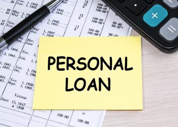 The inscription personal loan on a yellow sheet that lies on the financial document near the calculator.