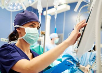 Nurse working with technology in operating room
