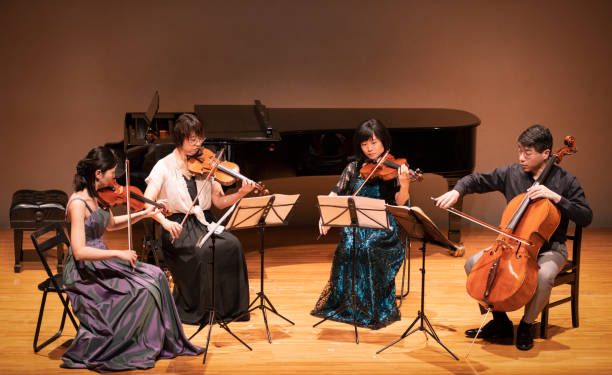 Four musicians playing violin and cello at classical music concert
