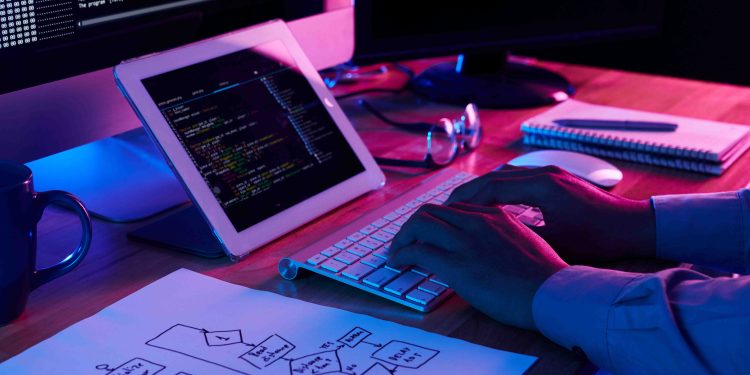 Close-up image of programmer working at his desk in office