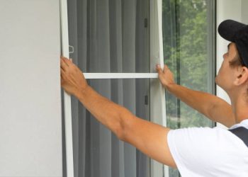 A worker Install Mosquito Net on Windows. Protection from flying insects